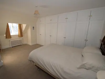 a bedroom with white cabinets and a large bed at Top Deck at The Cabin in Fornham Saint Martin