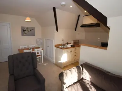 a living room with a couch and a kitchen at Top Deck at The Cabin in Fornham Saint Martin