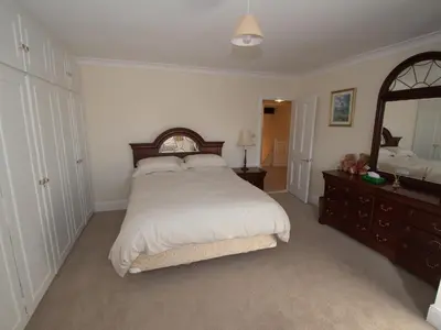 a bedroom with a large bed and a large mirror at Top Deck at The Cabin in Fornham Saint Martin