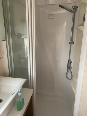 a shower with a glass door next to a sink at Lakeside Lodge Valencia 2 bedroom in Weeley
