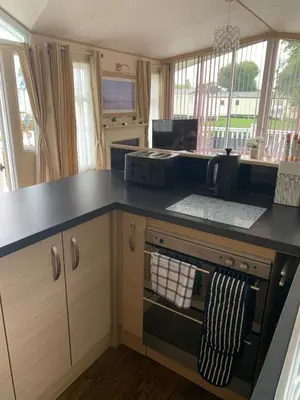 a kitchen with a black counter top with a microwave at Lakeside Lodge Valencia 2 bedroom in Weeley
