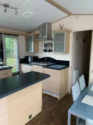 a kitchen with a black counter top and white cabinets at Lakeside Lodge Valencia 2 bedroom in Weeley