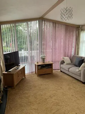 a living room with a couch and a tv at Lakeside Lodge Valencia 2 bedroom in Weeley