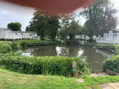 a small river with houses in the background and a house at Lakeside Lodge Valencia 2 bedroom in Weeley