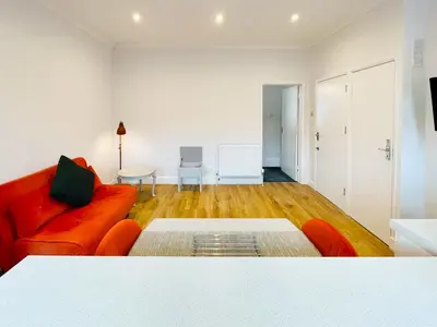 a living room with a red couch and a table at Sea Leigh in Leigh-on-Sea