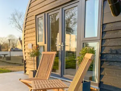 two chairs sitting on a porch in front of a house at The Nissen Hut in Laxfield
