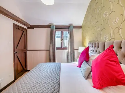 a bedroom with a large bed with red pillows at Robin - Uk48171 in Colchester