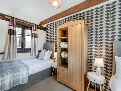a bedroom with a bed and a wooden cabinet at Partridge - Uk48173 in Colchester