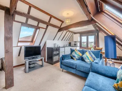 a living room with a blue couch and a tv at Plover - Uk48174 in Colchester