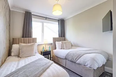 a bedroom with two beds and a window at Modern 5-Bed Property, Ideal for Extended Business & Contractor Stays in Colchester