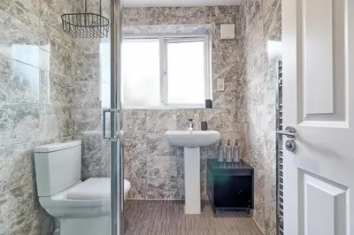 a bathroom with a toilet and a sink and a window at Modern 5-Bed Property, Ideal for Extended Business & Contractor Stays in Colchester