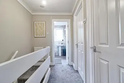 a hallway with a white door and a white sink at Modern 5-Bed Property, Ideal for Extended Business & Contractor Stays in Colchester