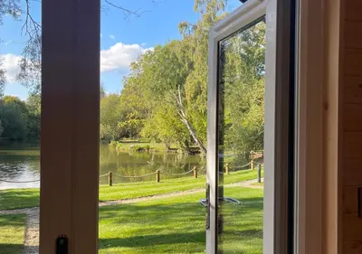 a view from a door looking out at a lake at Great Hallingbury Lodges in Hallingbury