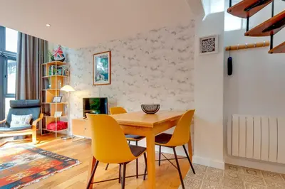 a dining room with a wooden table and yellow chairs at 25A City Road · Luxury City centre townhouse with courtyard Pass the Keys in Cambridge