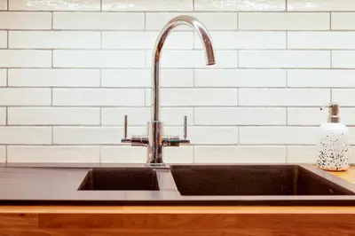 a kitchen sink with a faucet on a counter at 25A City Road · Luxury City centre townhouse with courtyard Pass the Keys in Cambridge