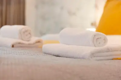 a pile of towels sitting on top of a bed at 25A City Road · Luxury City centre townhouse with courtyard Pass the Keys in Cambridge