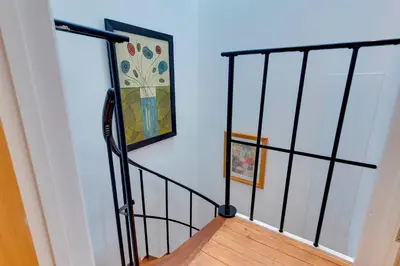 a stairway with a painting and a picture on a wall at 25A City Road · Luxury City centre townhouse with courtyard Pass the Keys in Cambridge