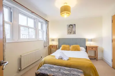 a bedroom with a bed in a room with windows at Fabulous Central 3Bed Apt - With Parking in Cambridge