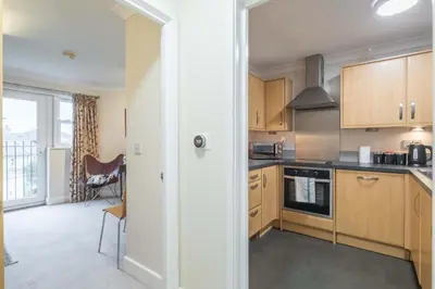 a kitchen with wooden cabinets and a stove top oven at Fabulous Central 3Bed Apt - With Parking in Cambridge