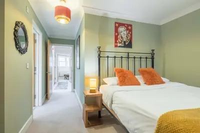 a bedroom with a large bed with orange pillows at Fabulous Central 3Bed Apt - With Parking in Cambridge
