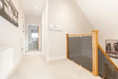 a hallway with white walls and a staircase with a glass door at Contemporary 3 Bedroom Fully Detached Town House in Wickford