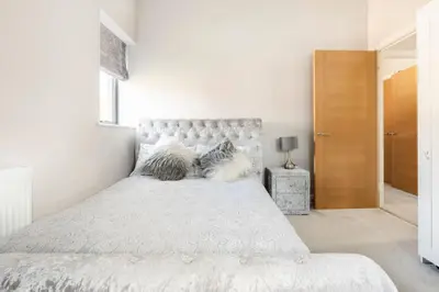a white bedroom with a large bed with a headboard at Contemporary 3 Bedroom Fully Detached Town House in Wickford