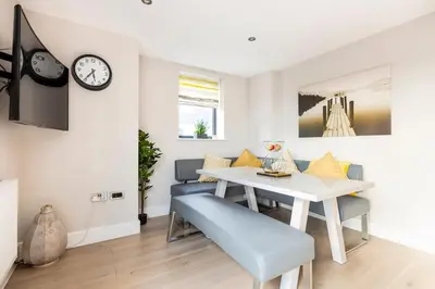a dining room with a white table and chairs at Contemporary 3 Bedroom Fully Detached Town House in Wickford