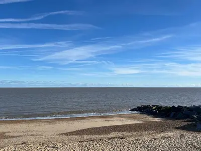 a beach with rocks and the ocean on a sunny day at Unique Apartment with Stunning Views 2B in Felixstowe