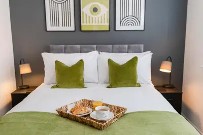 a bed with a tray of food on it at Caboose Stays - Bury St Edmunds - Modern 4 Bed townhouse close to centre and major transport links - Fast Wifi - Parking - Business and Contractors in Bury Saint Edmunds