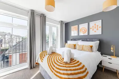 a bedroom with a bed and a large window at Caboose Stays - Bury St Edmunds - Modern 4 Bed townhouse close to centre and major transport links - Fast Wifi - Parking - Business and Contractors in Bury Saint Edmunds