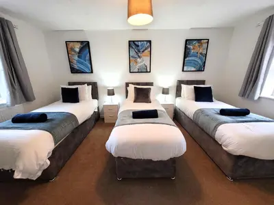 a room with three beds in a room at Hythe House - Stylish Stay for Families & Groups by Catchpole Stays in Colchester