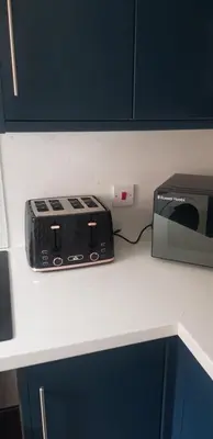 a kitchen counter with a microwave and a toaster at Hythe House - Stylish Stay for Families & Groups by Catchpole Stays in Colchester