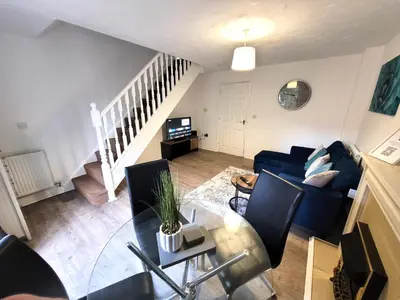 a living room with a blue couch and a table at Hythe House - Stylish Stay for Families & Groups by Catchpole Stays in Colchester