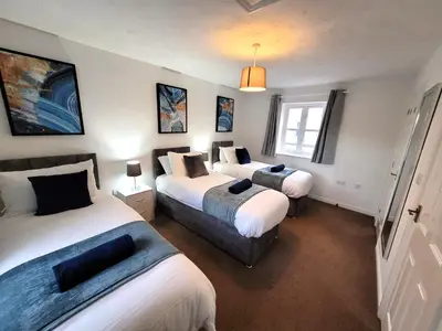 a hotel room with two beds and a window at Hythe House - Stylish Stay for Families & Groups by Catchpole Stays in Colchester