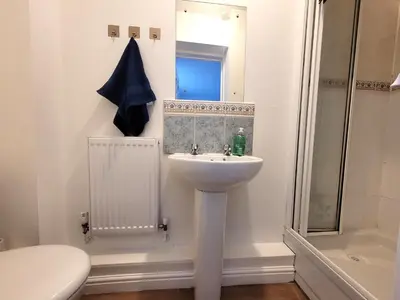 a white bathroom with a sink and a toilet at Hythe House - Stylish Stay for Families & Groups by Catchpole Stays in Colchester