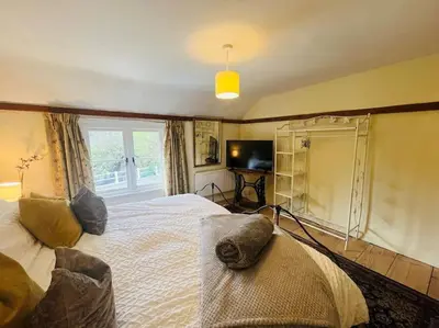 a bedroom with a large bed and a window at Beautifully Quaint Cottage in Yelling