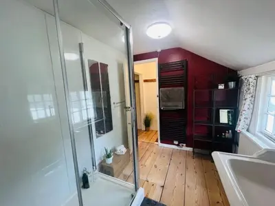 a bathroom with a glass shower and a sink at Beautifully Quaint Cottage in Yelling