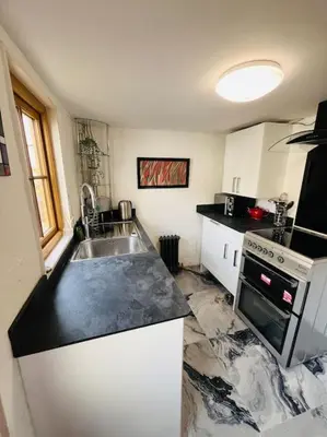 a kitchen with a sink and a stove at Beautifully Quaint Cottage in Yelling