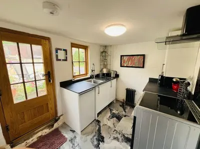 a kitchen with a sink and a counter top at Beautifully Quaint Cottage in Yelling