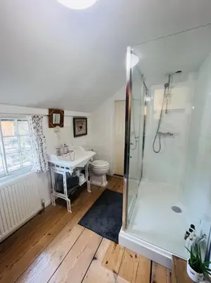 a bathroom with a shower and a toilet and a sink at Beautifully Quaint Cottage in Yelling