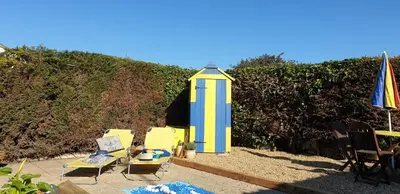 a group of chairs and a lighthouse on a beach at Rainbow on Sea Frinton-on-Sea in Kirby Cross