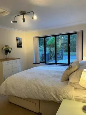 a bedroom with a bed and a large window at The Annex in Tostock
