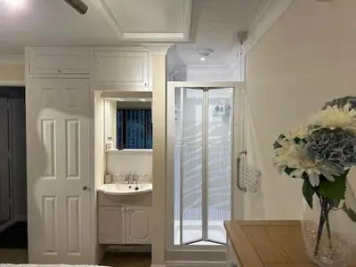 a bathroom with a sink and a vase of flowers at The Annex in Tostock