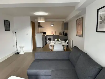 a living room with a couch and a table and a kitchen at 1 bed spacious flat in Essex in Brentwood