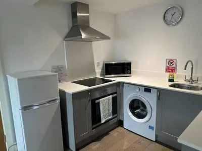 a kitchen with a stove and a washing machine at 1 bed spacious flat in Essex in Brentwood