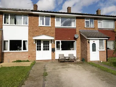 a brick house with white doors and a bench at 25 Resbury Close in Cambridge