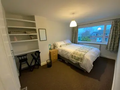 a bedroom with a large bed and a window at 25 Resbury Close in Cambridge