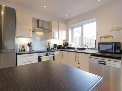 a kitchen with white cabinets and a black counter top at 25 Resbury Close in Cambridge