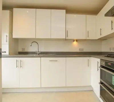 a kitchen with white cabinets and a sink at Colchester Retreat 4br 2bath Ample Street Parking in Colchester