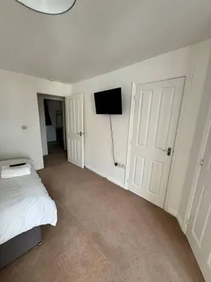 a bedroom with a bed and a flat screen tv at Colchester Retreat 4br 2bath Ample Street Parking in Colchester